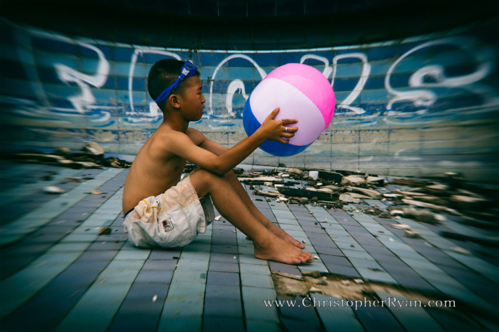 shirtless boy in abandoned swimming pool
