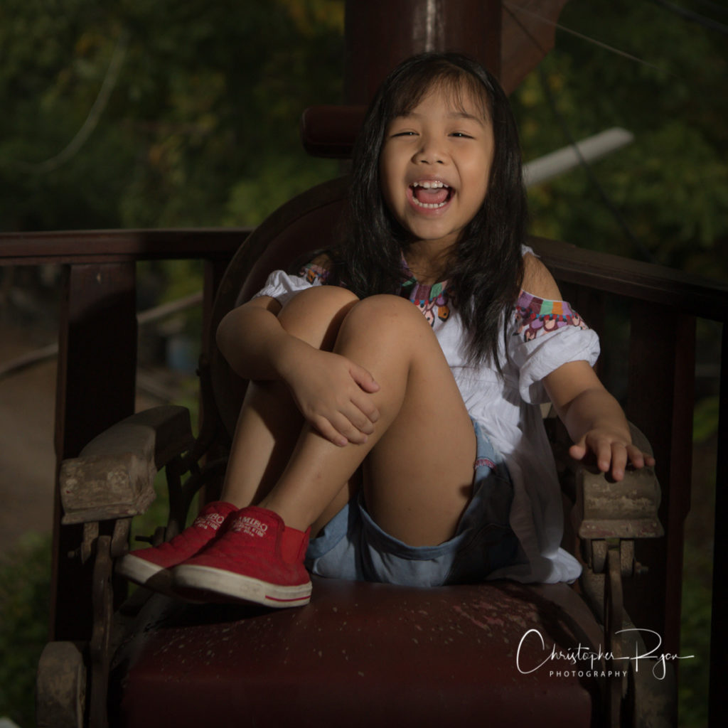 adorable little girl in red sneakers on antique barber chair