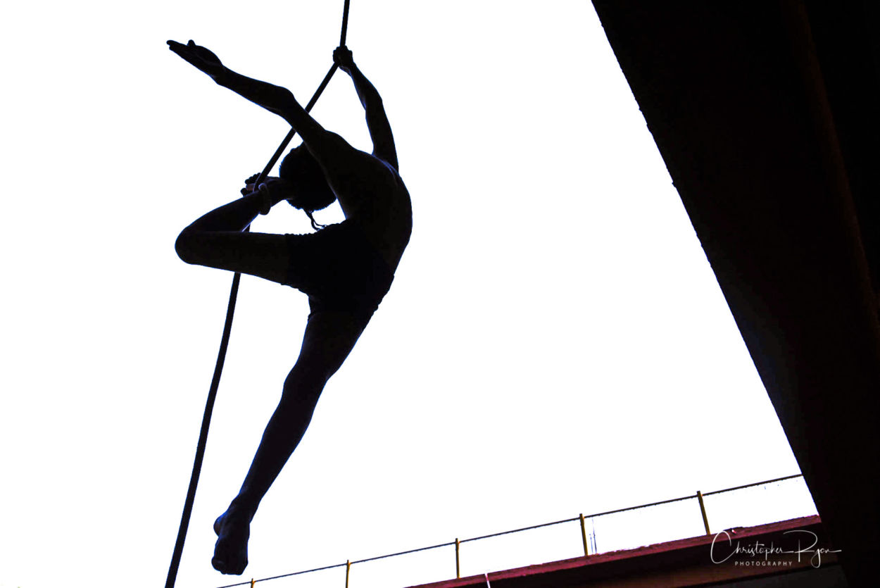 silhouete of a beautiful shirtless athletic boy performing aerial arts