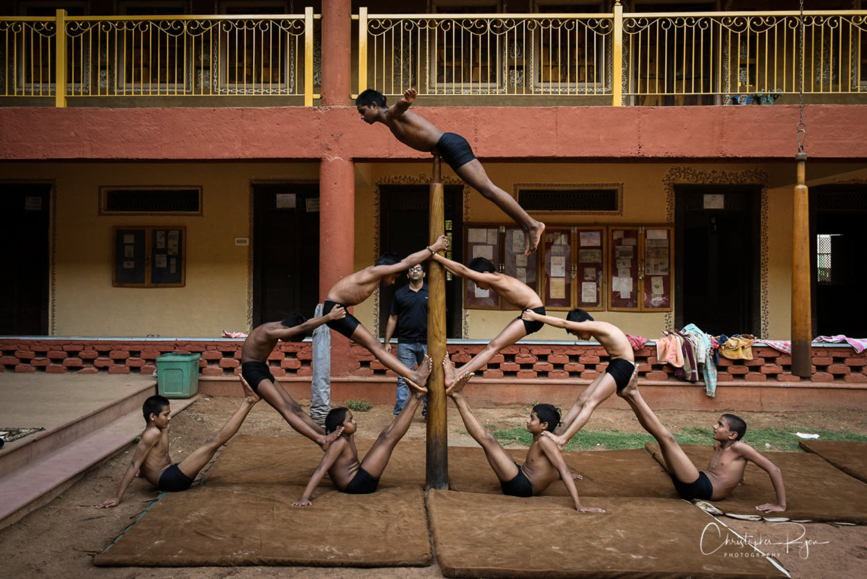 shirtless mallakhamb performers create a beautiful group pose at a gurukulum 