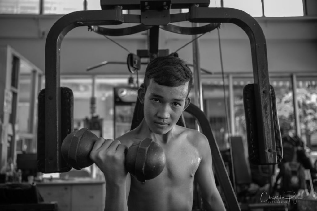 shirtless teenage boy in vintage gym - black and white photo