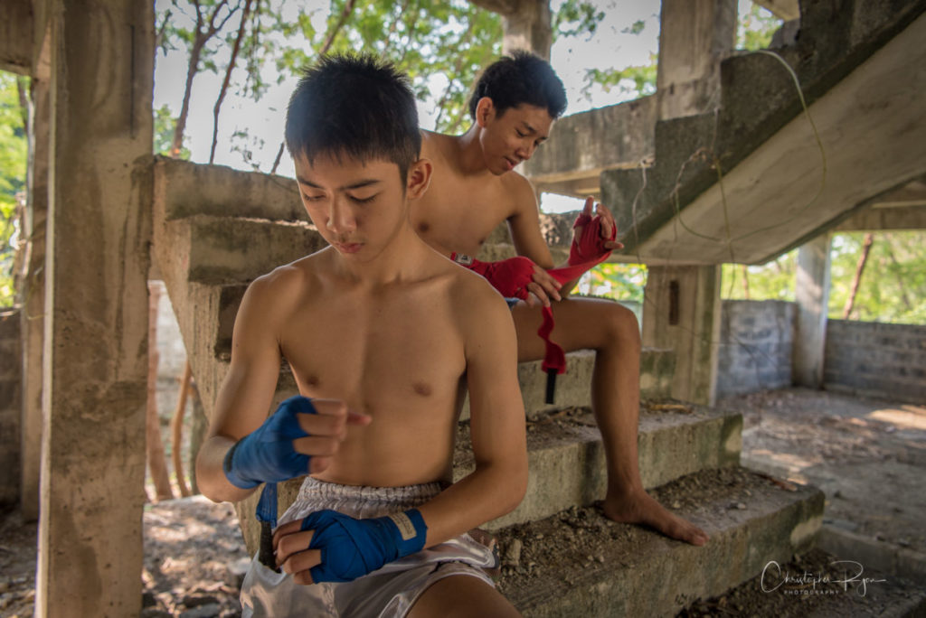 Teenage boys taping their hands before a Muay Thai fight