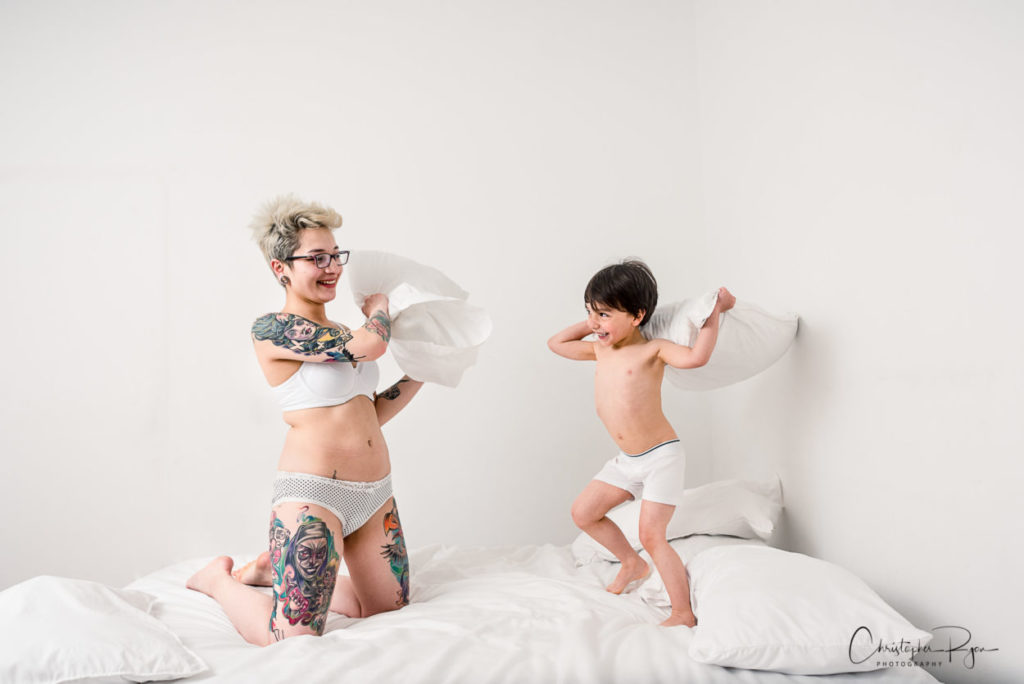 boy and mom in white undies having a pillow fight