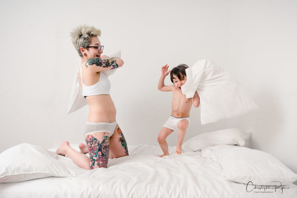 boy and mom having a pillow fight in their underwear
