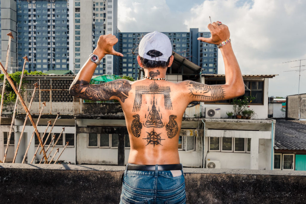back of thailand teenager with Buddhist tattoos