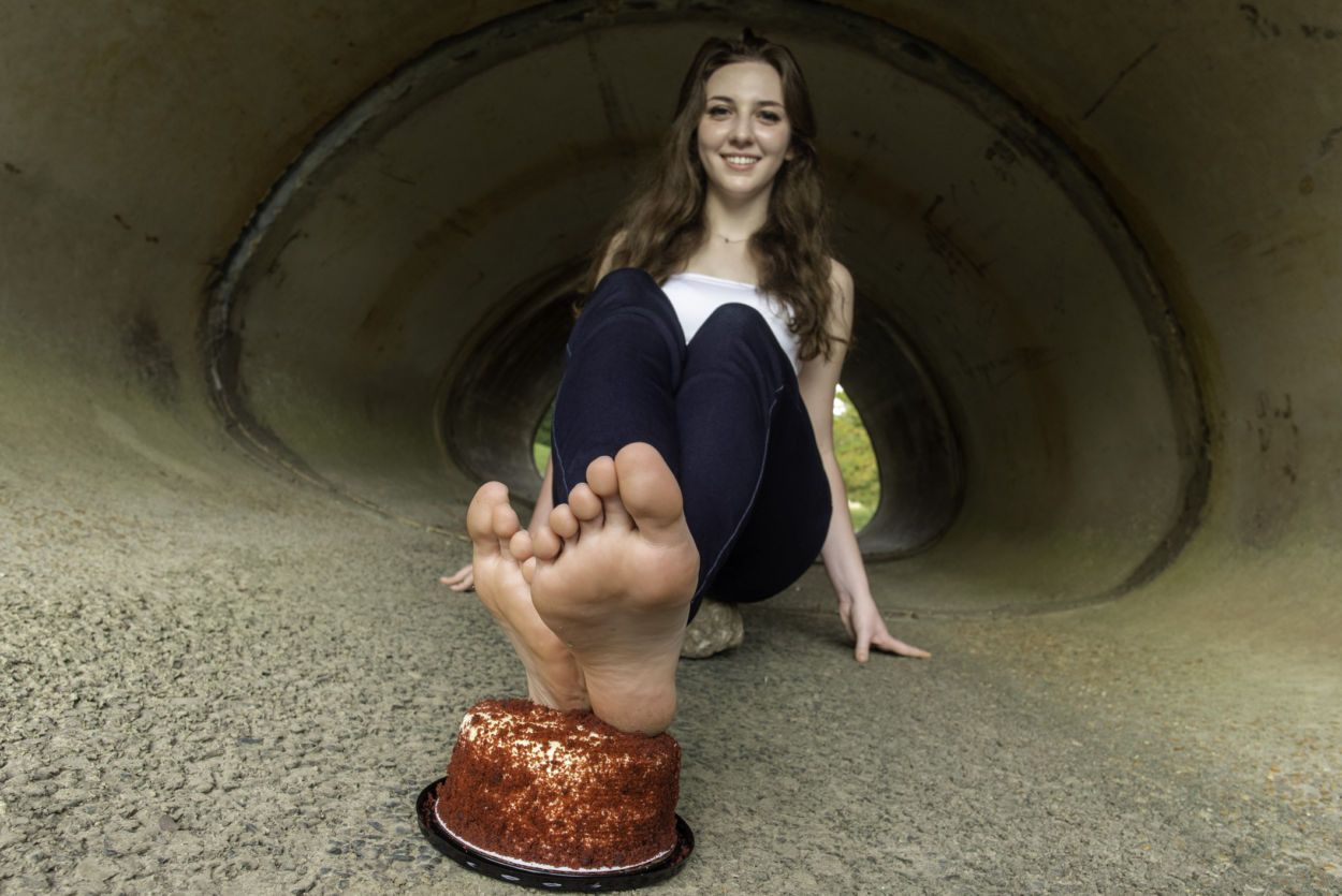 Girl with feet on a red velvet cake