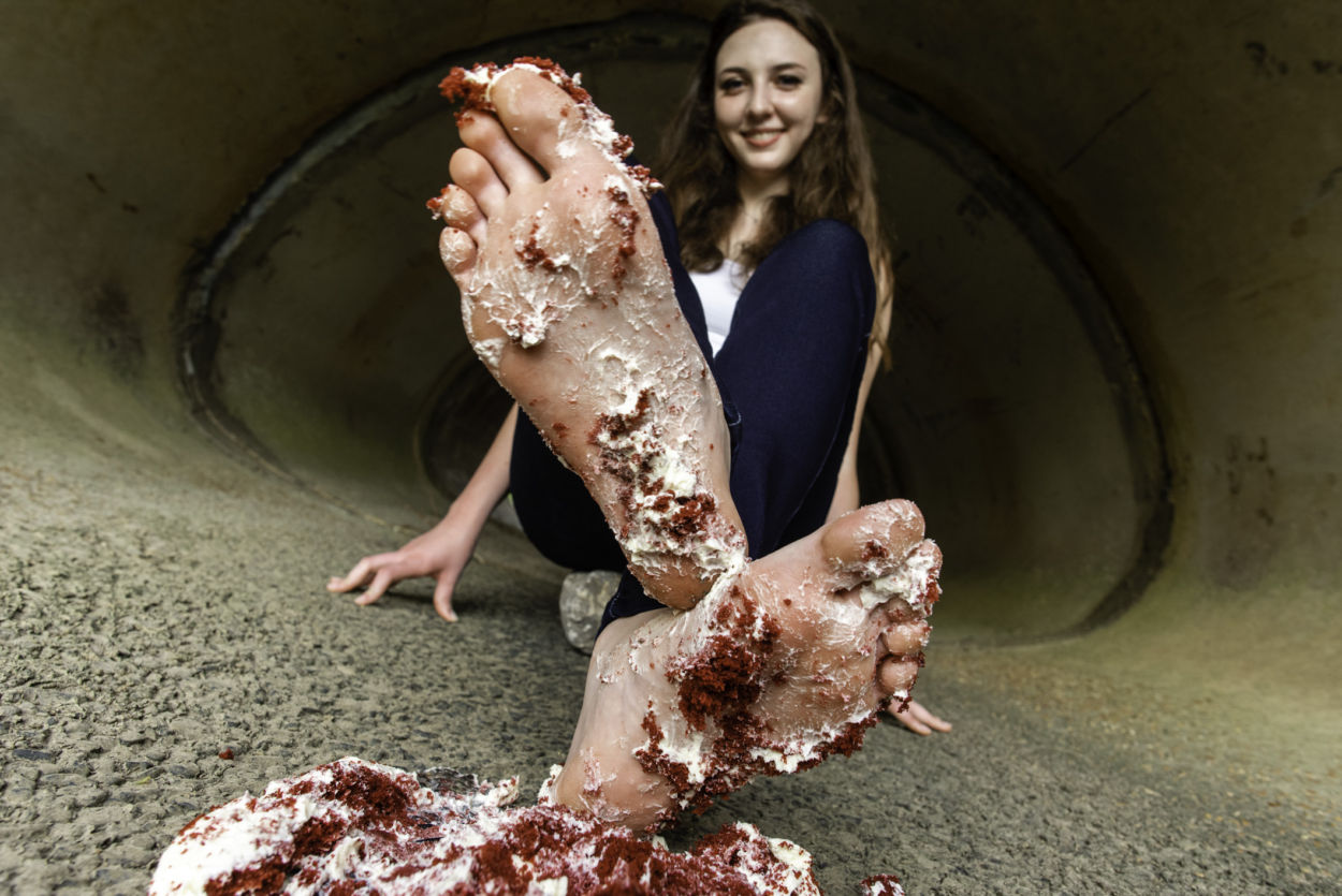 Girl with cake icing all over the soles of her feet